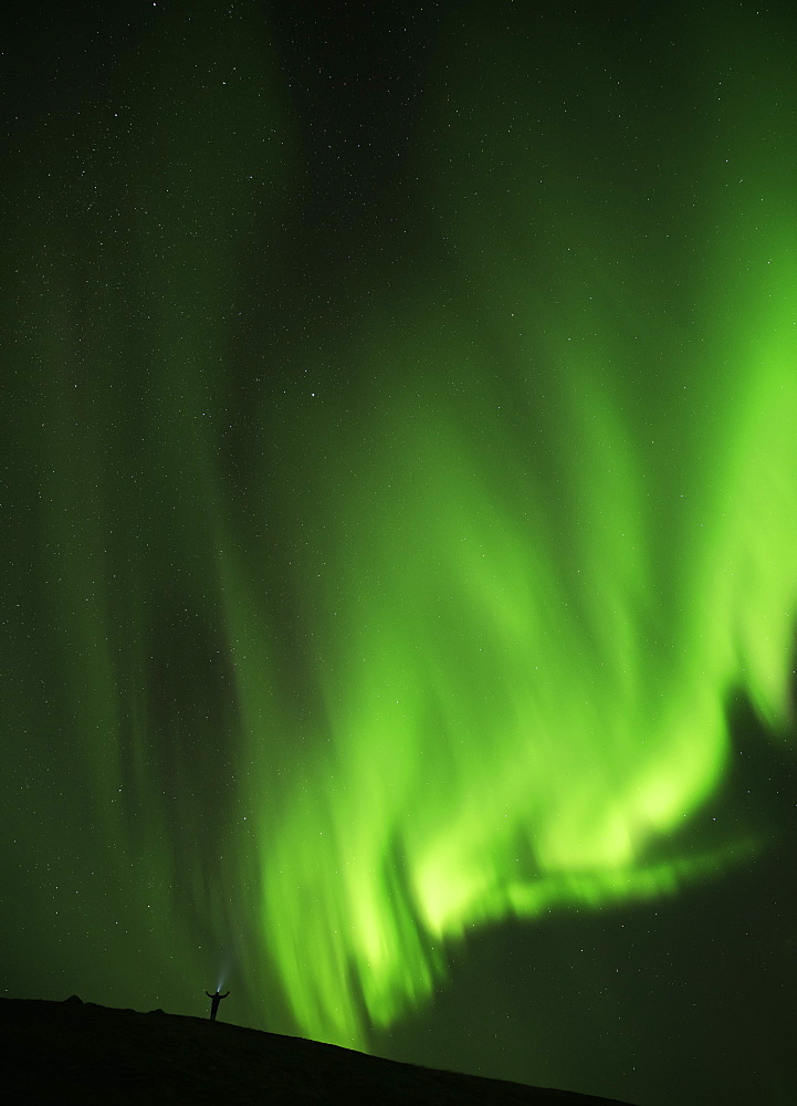 Man Standing Under A Bright Display Of The Northern Lights, Iceland