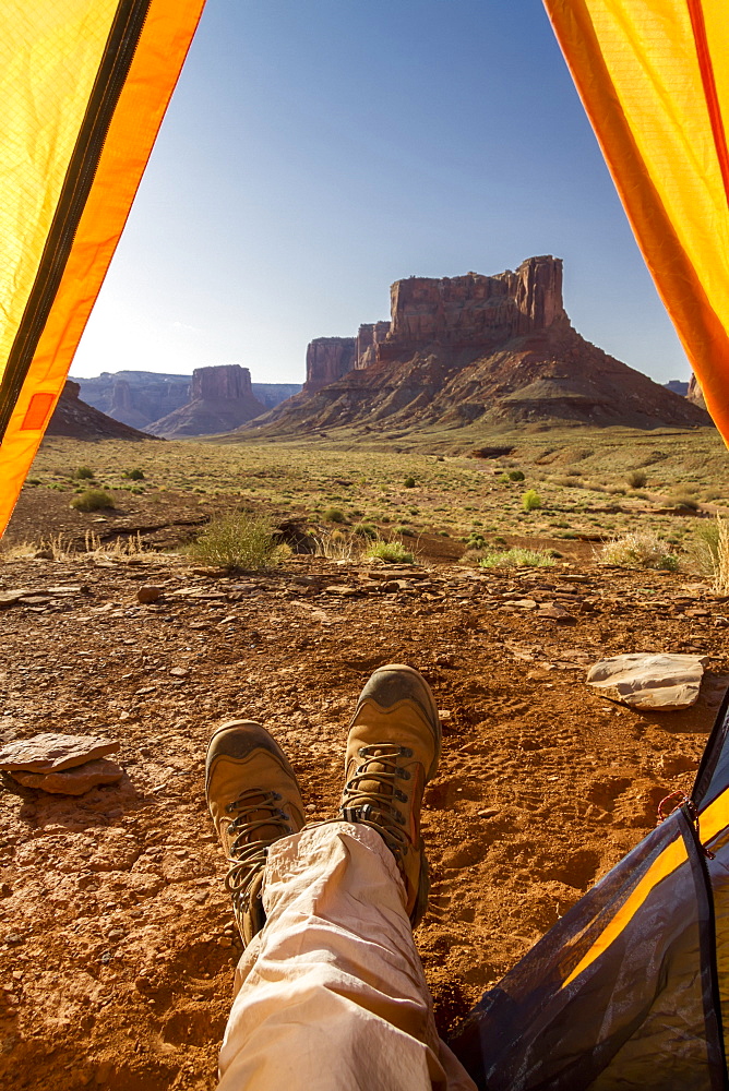 View Of A Camper's Feet Out Of A Tent Viewing Rock Cliffs, Canyonlands National Park, Utah, United States Of America