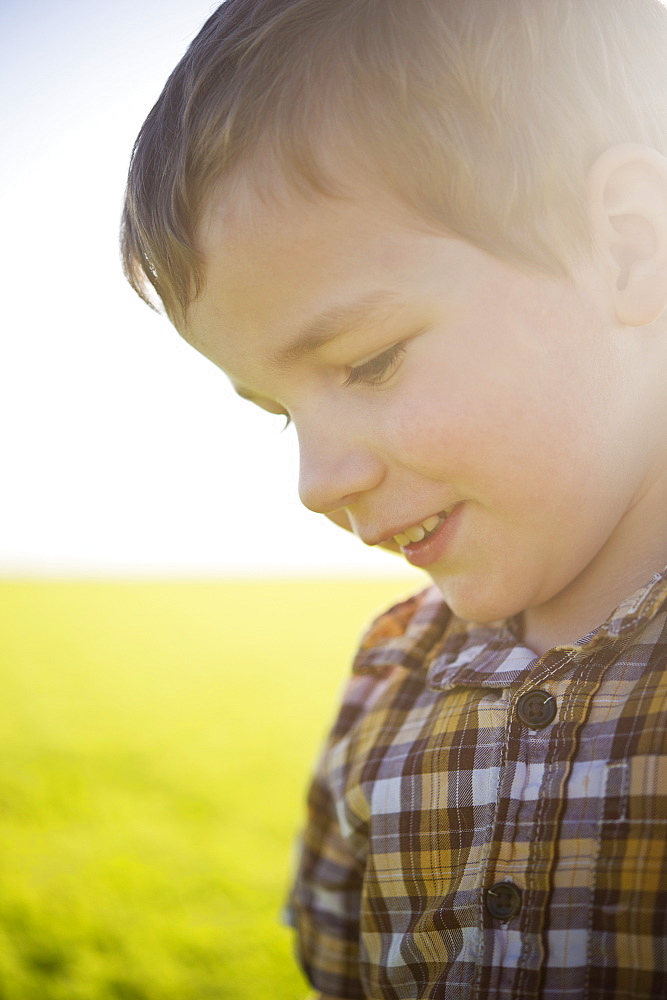 Young Boy's Profile With Sunlight Hitting His Face In A Farm Field, Saskatchewan, Canada