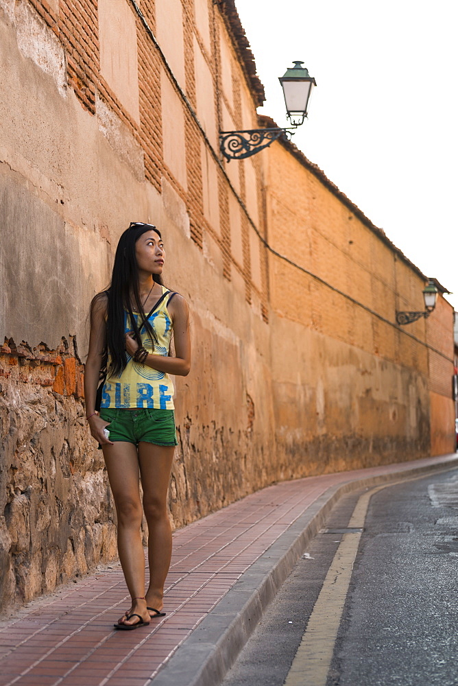 A Young Chinese Woman Walking Around Downtown Alcala De Henares, A Historical And Charming City Near To Madrid, Alcala De Henares, Spain