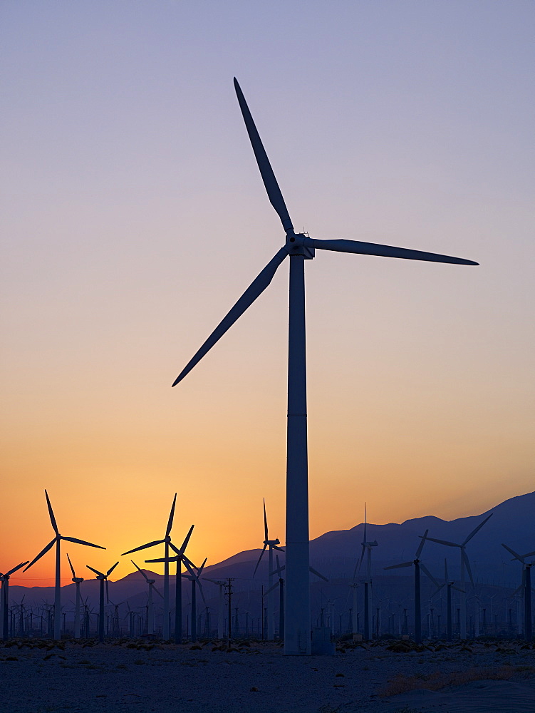 Silhouette Of Wind Turbines In A Field With A Mountain Range In The Distance At Sunset, Palm Springs, California, United States Of America