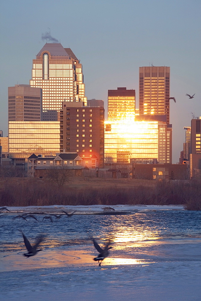 Calgary, Alberta, Canada; Bow River And Buildings Reflecting The Sun In Winter