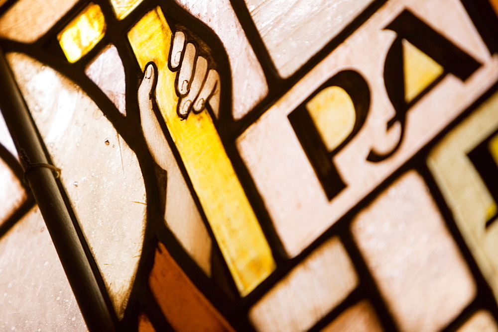 Close-up of a human hand holding a cross