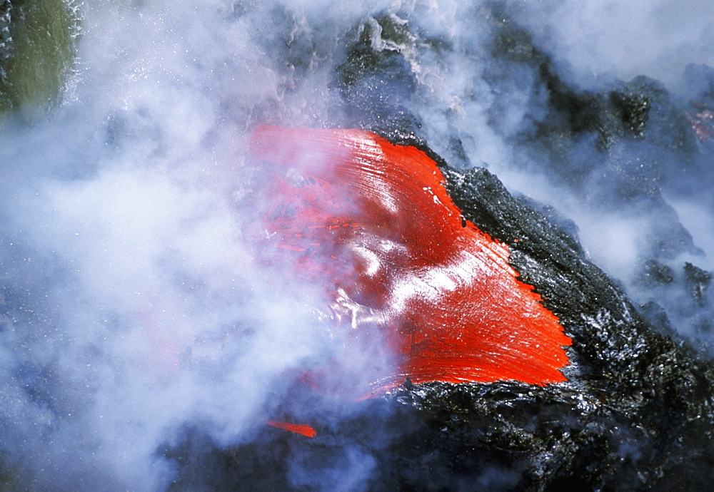 Steam rises from lava flowing into the sea, Hawaii