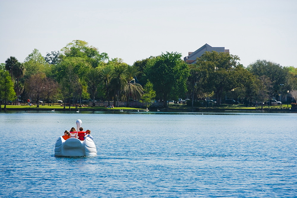 Four people on a pedal boat, Lake Eola Park, Orlando, Florida, USA