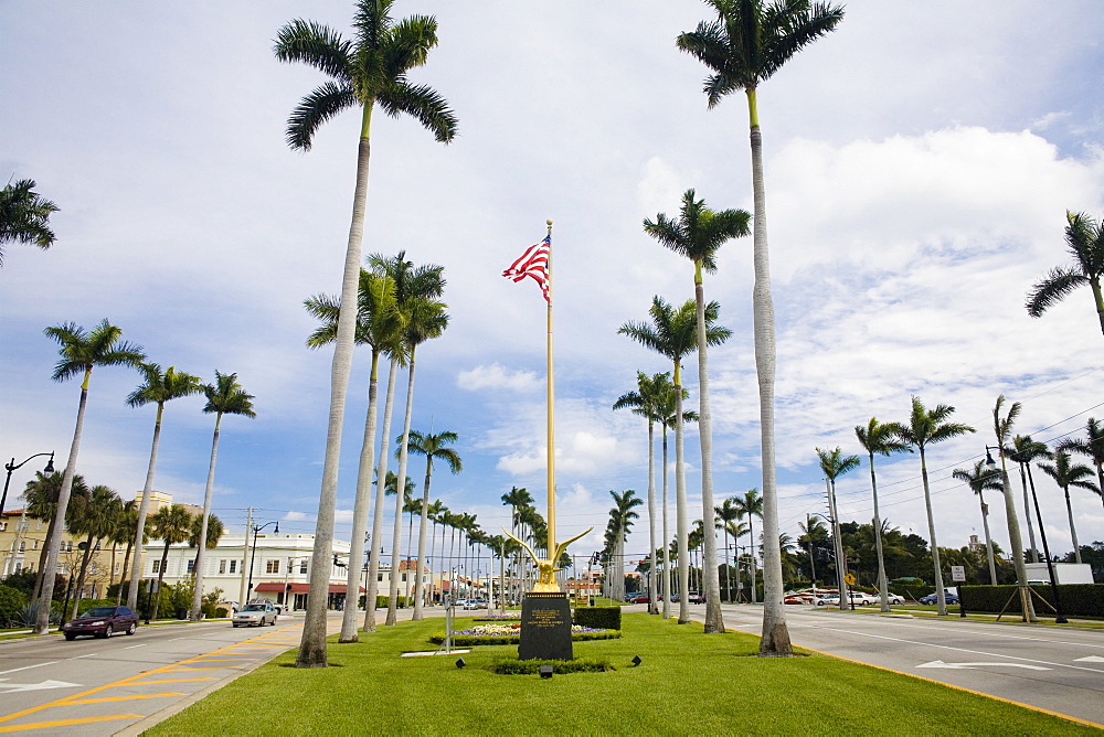 Low angle view of an American flag with palm trees, Royal Poinciana Way, Palm Beach, Florida, USA