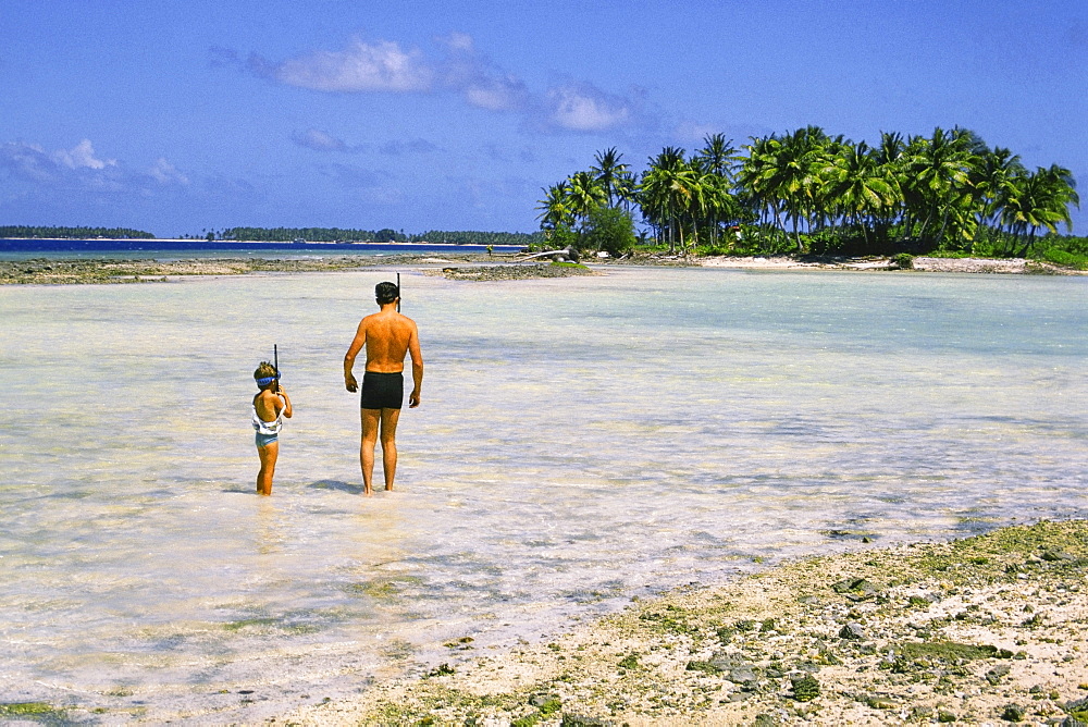 Man and a child standing on the beach, Majuro, Marshall Islands