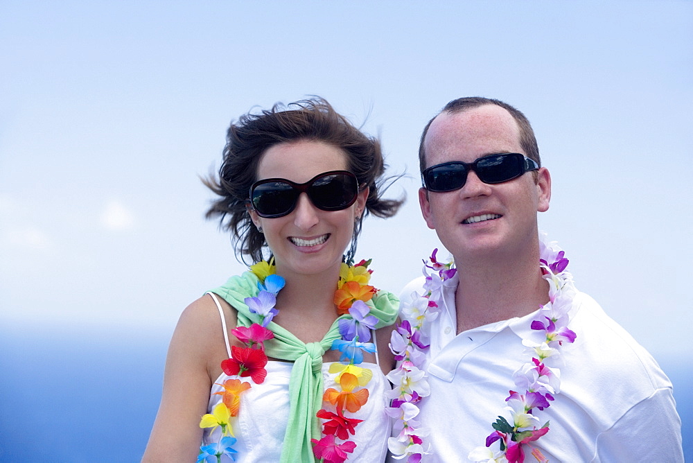 Mid adult couple wearing garlands and smiling