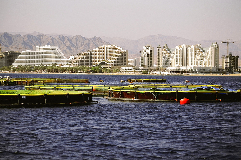 Fish farms in the sea with buildings in the background, Red Sea, Eilat, Israel