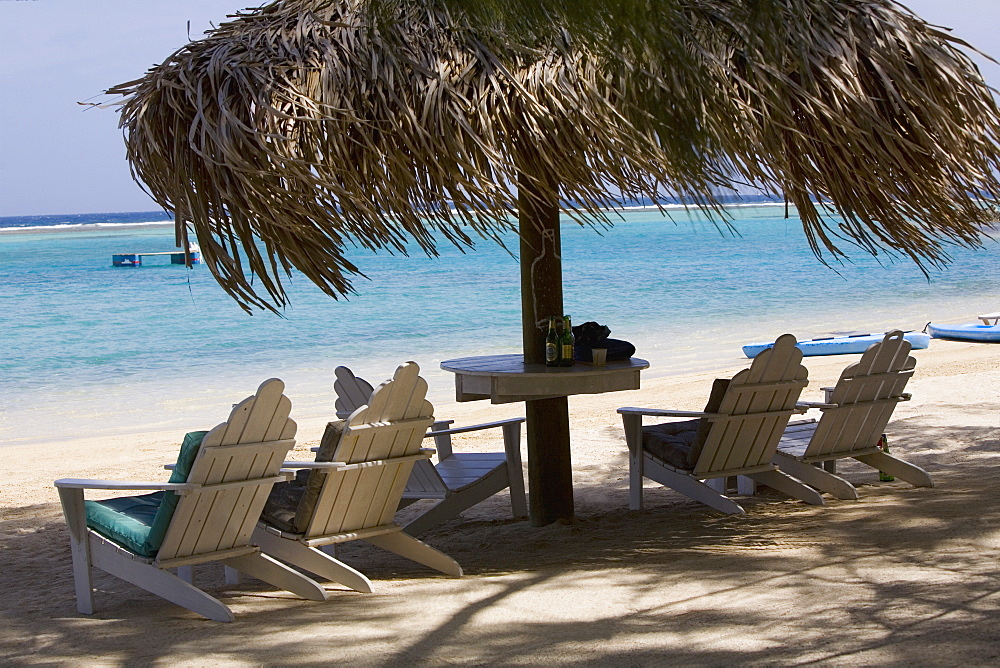 Beach chairs under palapa on the beach, Coral Cay, Dixon Cove, Roatan, Bay Islands, Honduras