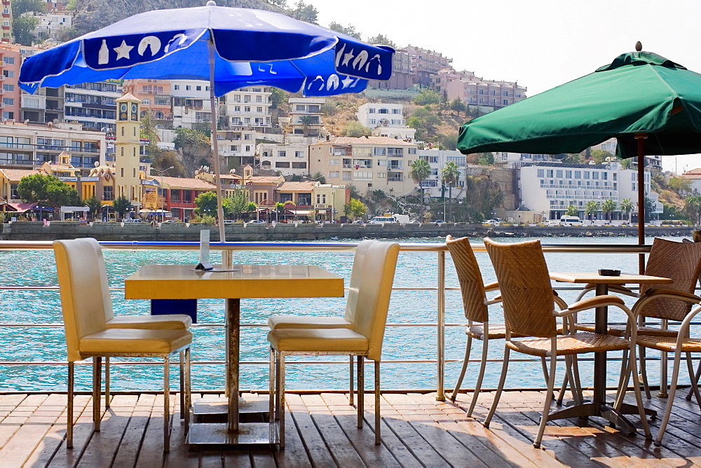 Empty chairs and tables in a restaurant with buildings in the background, Ephesus, Turkey