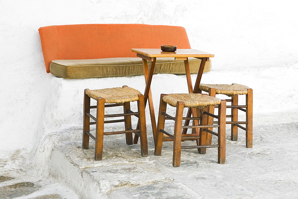 Empty table with three stools in a restaurant, Mykonos, Cyclades Islands, Greece