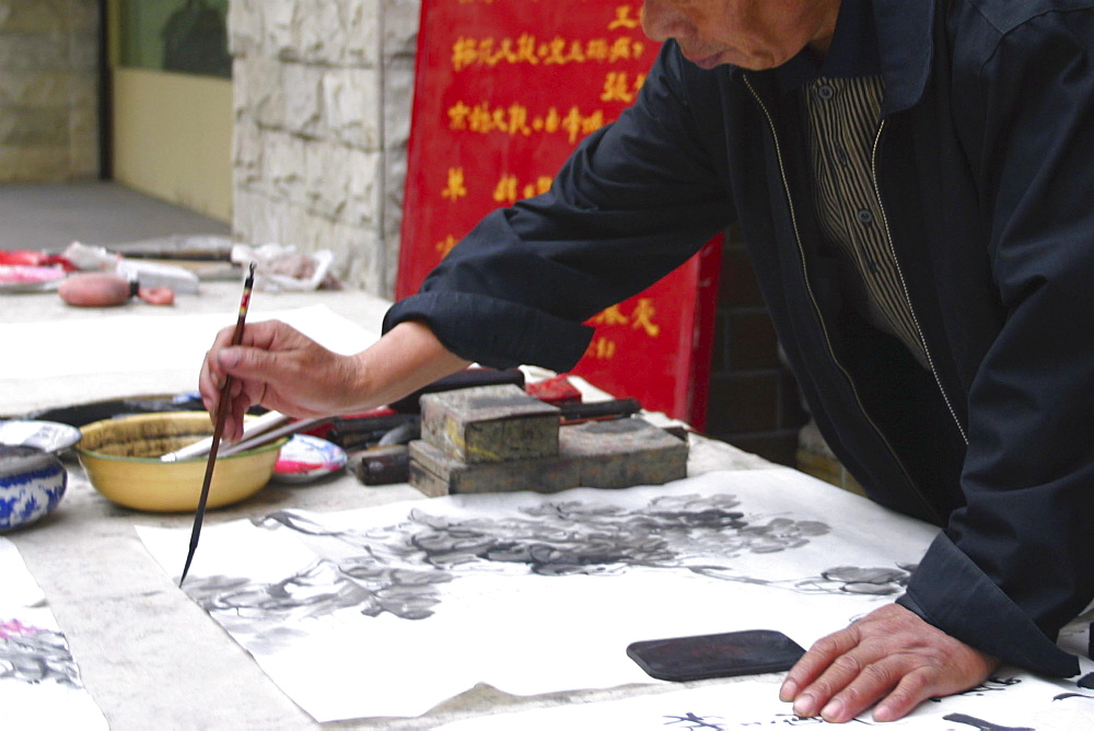 Mid section view of a man calligraphing, Beijing, China