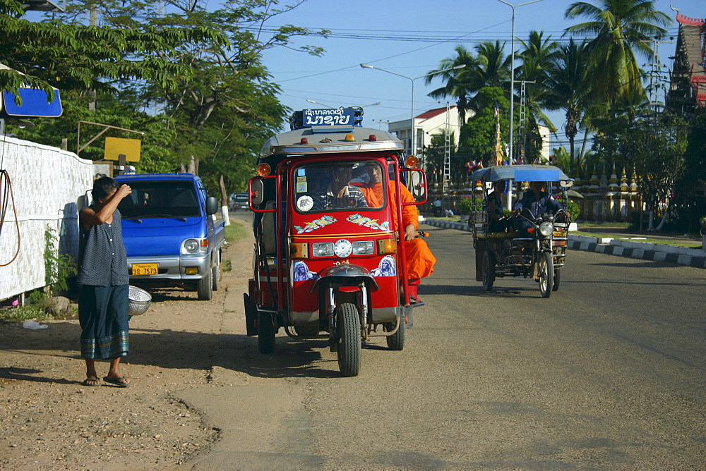 Passengers traveling in a jinrikisha, Luang Prabang, Laos