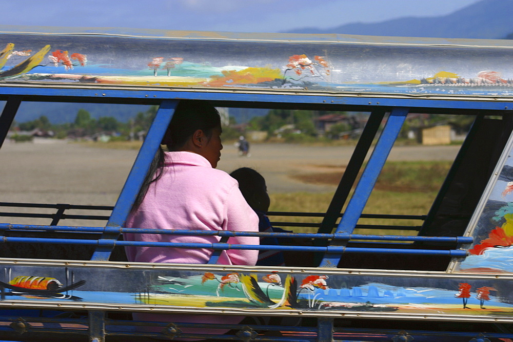 Passengers traveling in a jinrikisha, Vang Vieng, Laos