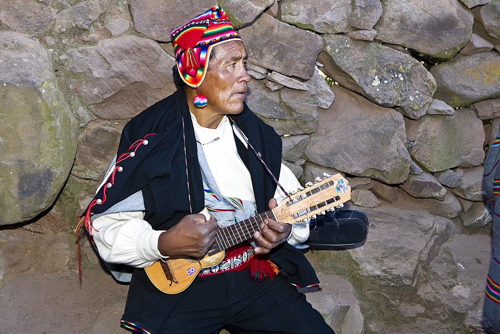 Close-up of a senior man playing a ukulele, Taquile Island, Lake Titicaca, Puno, Peru