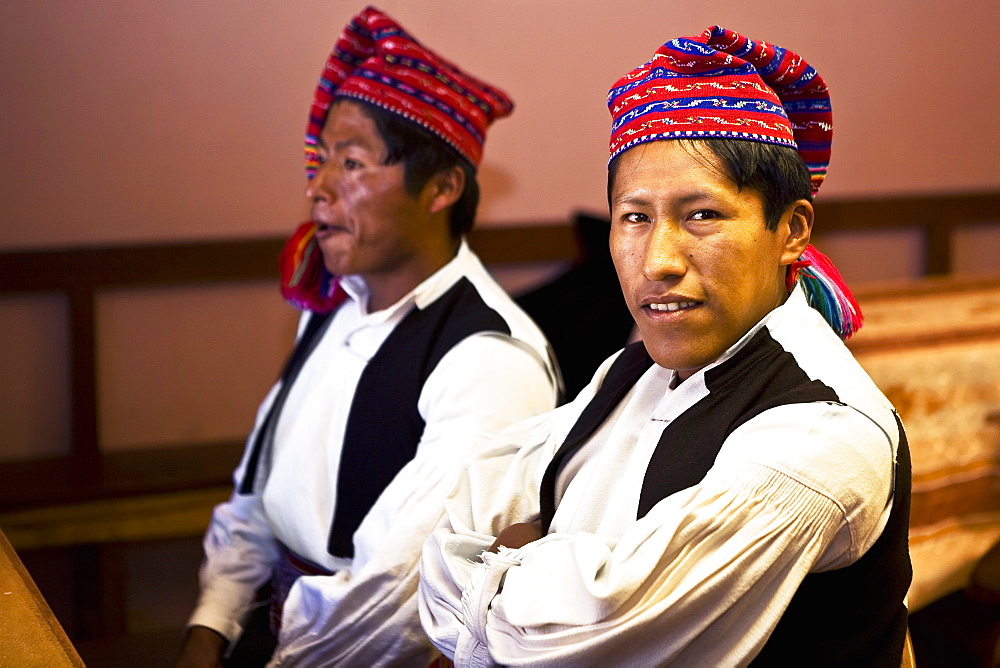 Close-up of two young men taking part in a wedding ceremony, Taquile Island, Lake Titicaca, Puno, Peru