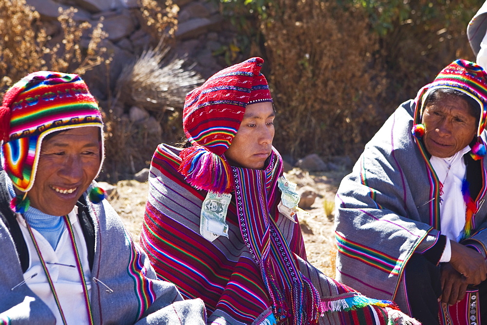 Mature man and a young man sitting with a groom, Taquile Island, Lake Titicaca, Puno, Peru