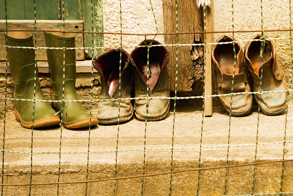 Close-up of a chain-link fence in front of shoes, Italian Riviera, Cinque Terre National Park, Vernazza, La Spezia, Liguria, Italy