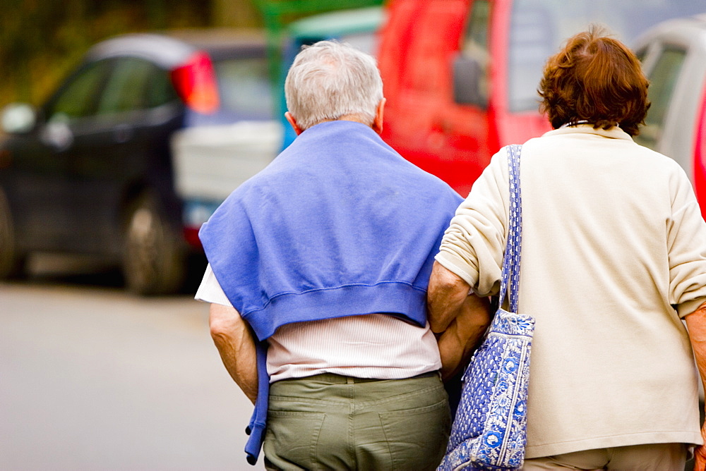 Rear view of a senior couple walking with arm in arm, Corniglia, Italian Riviera, Cinque Terre National Park, Vernazza, La Spezia, Liguria, Italy