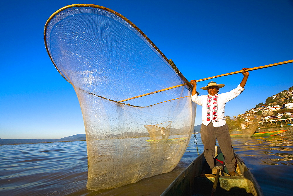 Fisherman with butterfly fishing net in a lake, Janitzio Island, Lake Patzcuaro, Patzcuaro, Michoacan State, Mexico