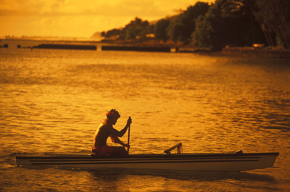 Silhouette of a person rowing a boat at dusk, Hawaii, USA