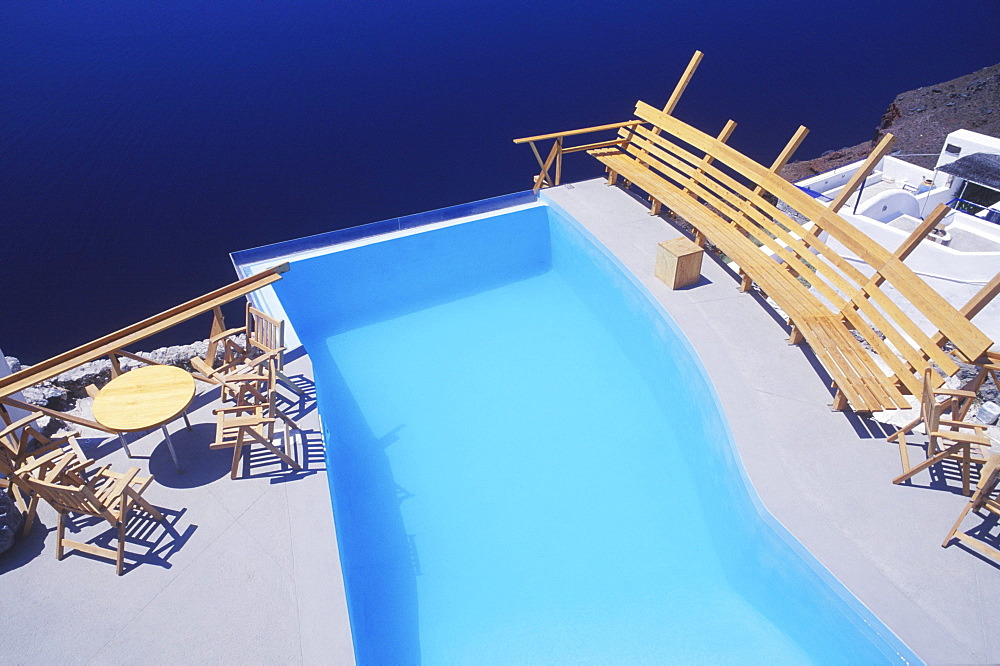 High angle view of a bench and chairs at the poolside