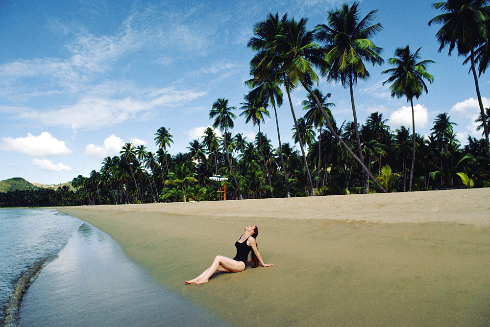 A woman relaxing on a beach, Puerto Rico