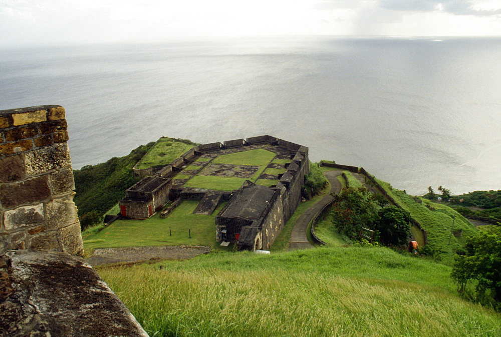 View of a lush meadow overlooking a vast sea, St. Kitts, Leeward Islands, Caribbean.