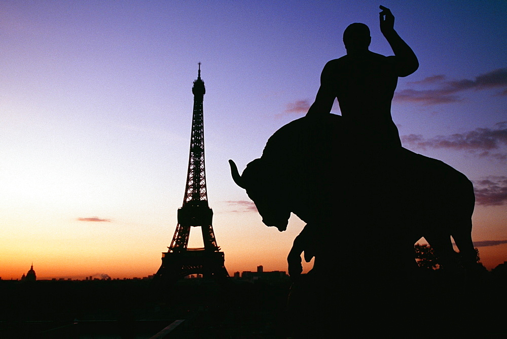 Silhouette of a statue with Eiffel tower and Eid Alliot Palace in the background, France