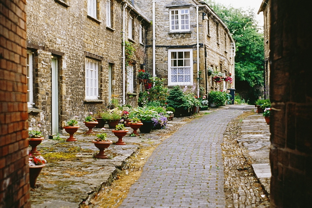 Side view of houses beside a cobblestone pavement, Burford, England