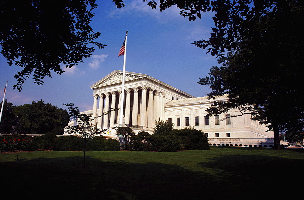 Low angle view of an American flag in front of a government building, US Supreme Court, Washington DC, USA