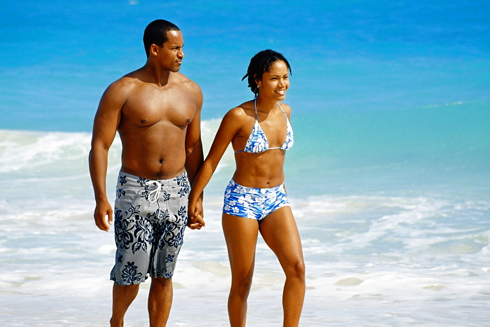 A couple walking near a seashore, Natural Arches Beach, Bahamas