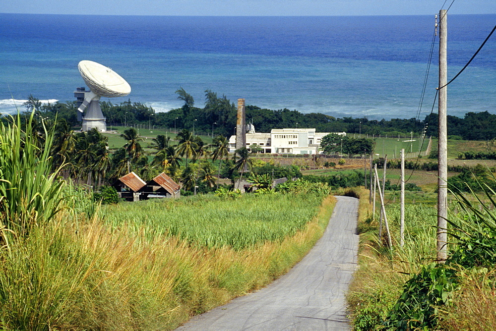 A road passing through lush meadows with a satellite dish at a side, Barbados, Caribbean