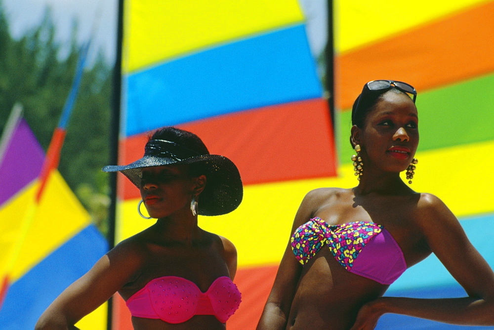 Two fashionable young women standing in front of sails at Crystal Palace Hotel, Nassau, Bahamas