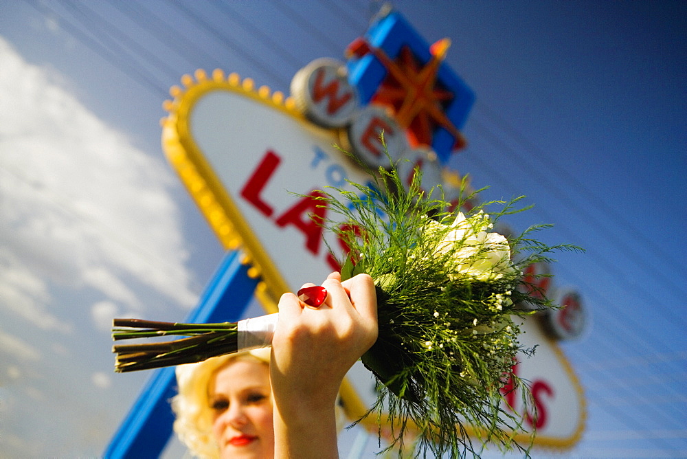 Low angle view of a mid adult woman holding a bouquet of flowers, Las Vegas, Nevada, USA