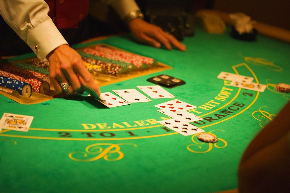 Mid section view of a casino dealer holding a playing card, Las Vegas, Nevada, USA