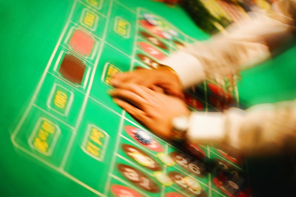 High angle view of a man's hand collecting gambling chip on a roulette table, Las Vegas, Nevada, USA