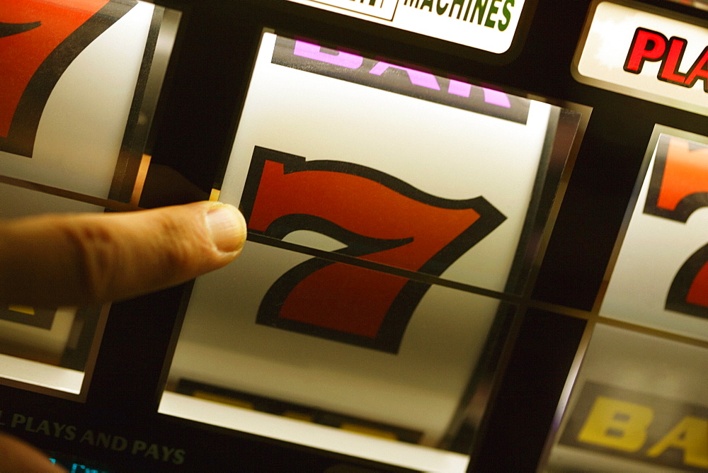 Close-up of a person's finger operating a slot machine, Las Vegas, Nevada, USA