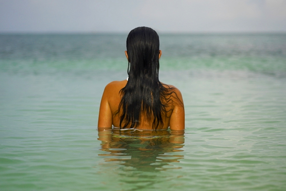 Rear view of a young woman in the water