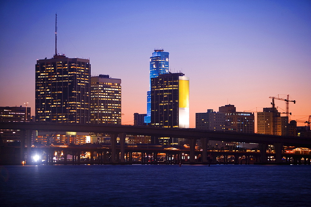 Buildings at the waterfront lit up at dusk, Miami, Florida, USA