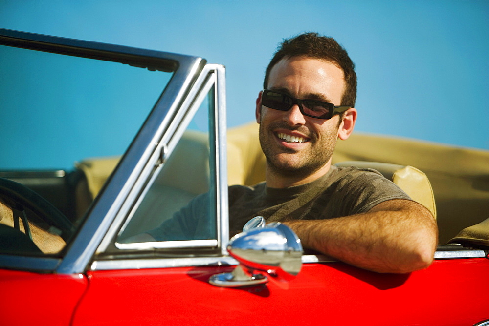 Close-up of a mid adult man sitting in a convertible car, Miami, Florida, USA