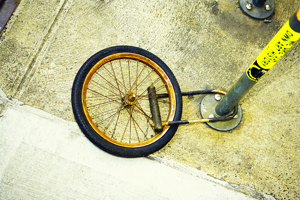 High angle view of a wheel locked to a pole