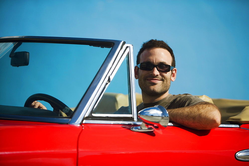 Close-up of a mid adult man sitting in a convertible car, Miami, Florida, USA