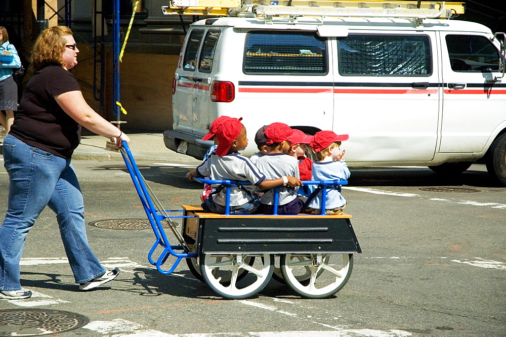 Mid adult woman pushing children in a trolley