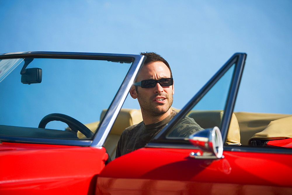 Mid adult man sitting in a convertible car, Miami, Florida, USA