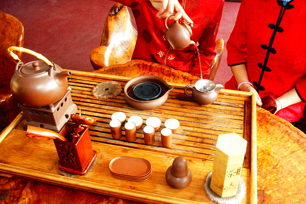 Mid section view of a woman pouring tea into a tea kettle, Tongli, Jiangsu Province, China