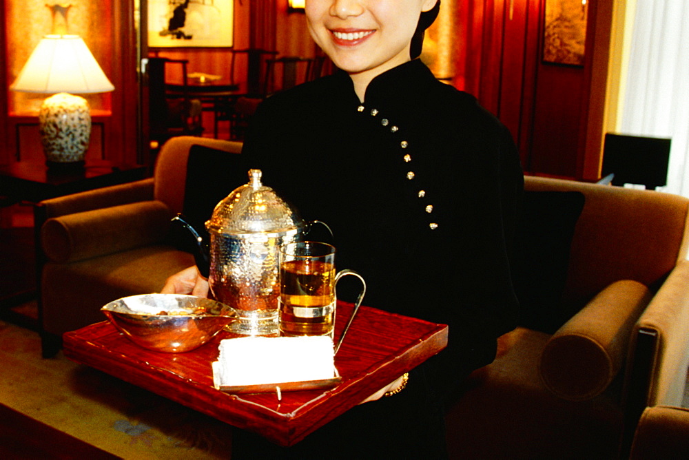 Waitress holding a serving tray and smiling, Shanghai, China