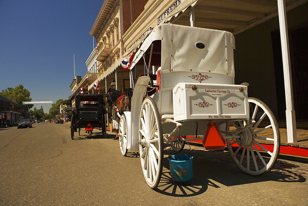 Two horse carts parked in front of a building