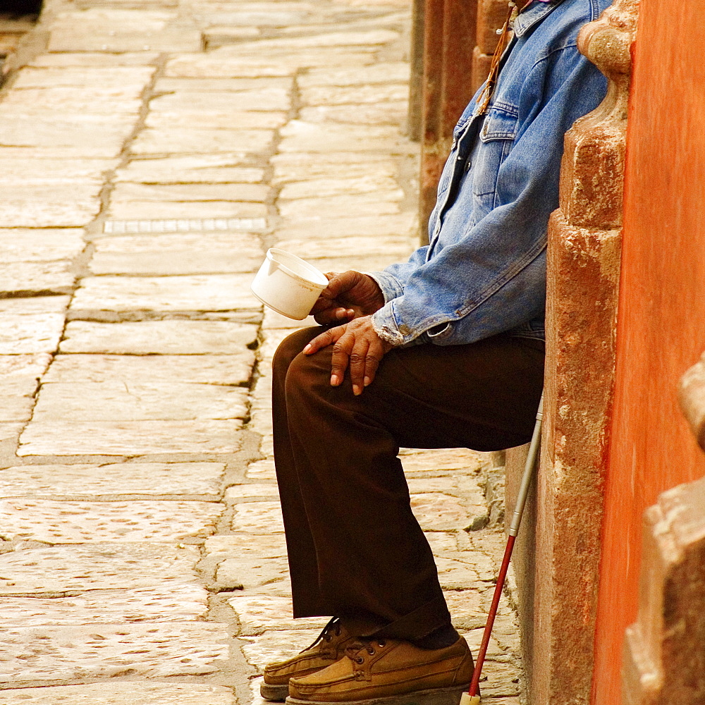 Side profile of a blind man holding a cup, Mexico